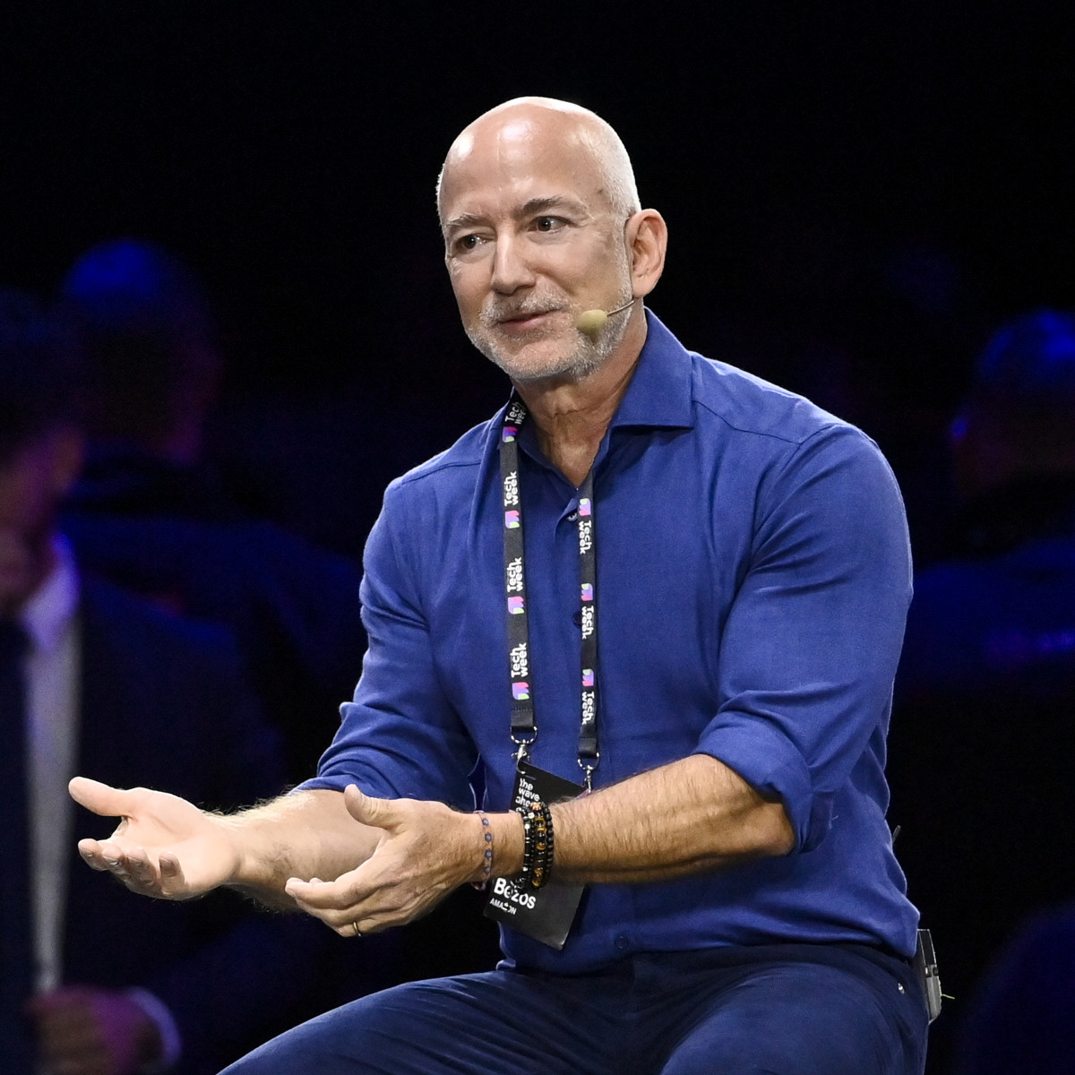 Jeff Bezos berbicara di pentas, simbol kejayaan Amazon dan konsep obsesi pelanggan.