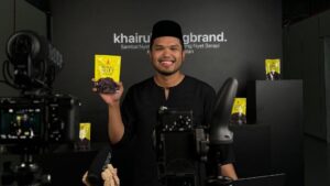Khairul Aming sedang bercakap dalam studio produksi, dikelilingi kamera dan peralatan rakaman, melambangkan disiplin kerja dan mindset jurutera di sebalik jenamanya.